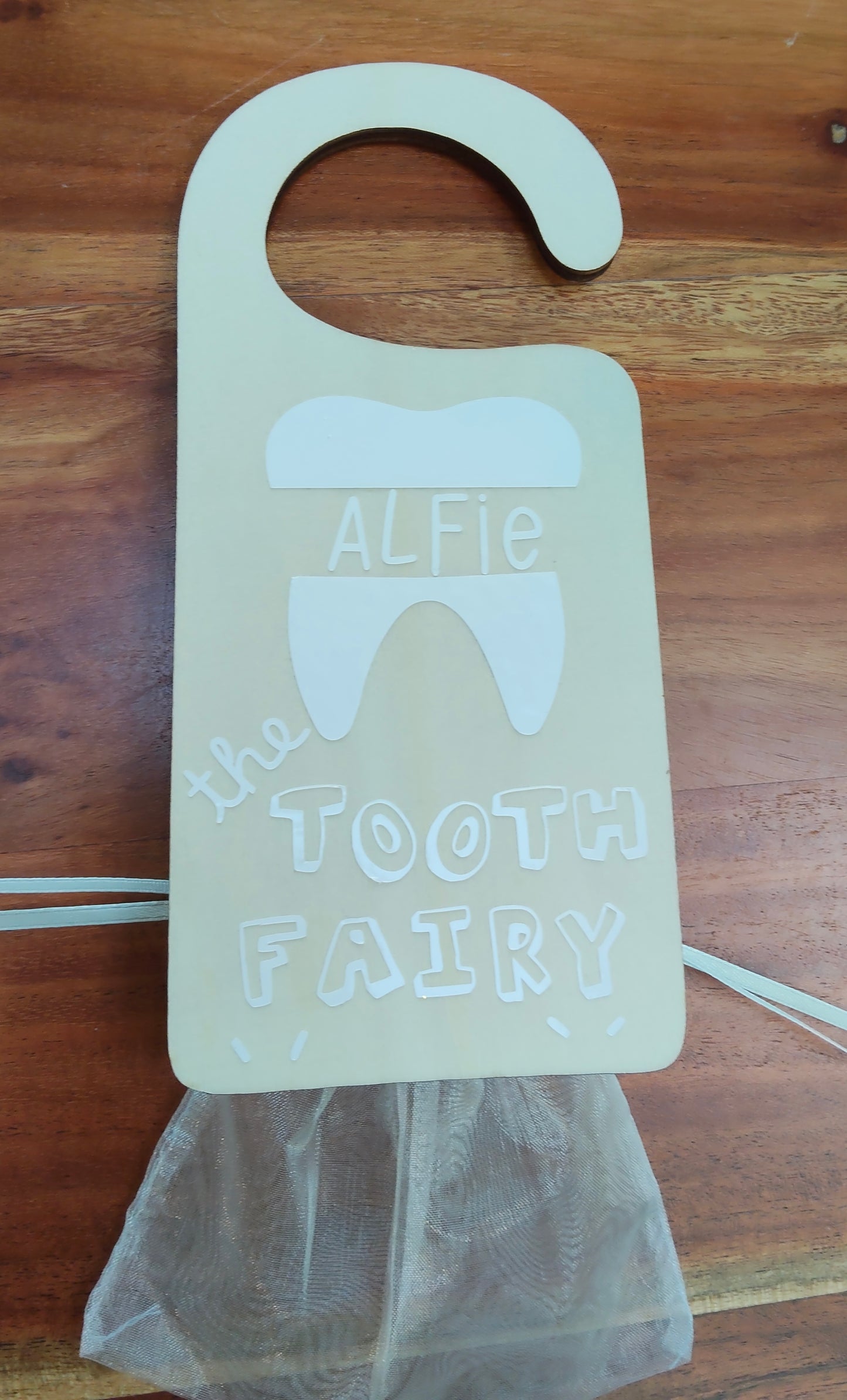 Door handle with a 'Tooth Fairy' holder personalised with name, 'lost tooth' bag attached.