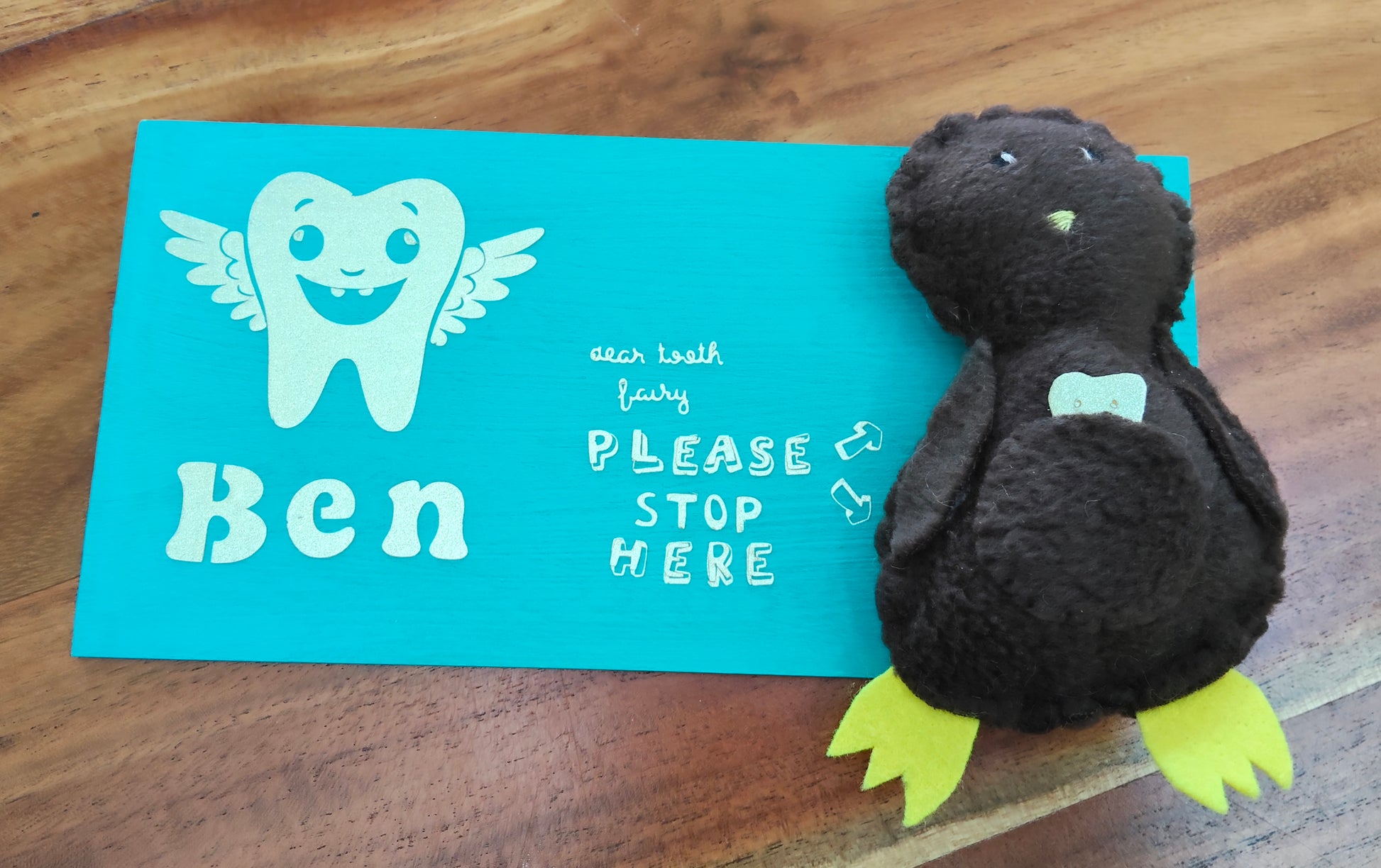 Plush Kiwi tooth pillow on a personalised wooden board, featuring a tooth illustration