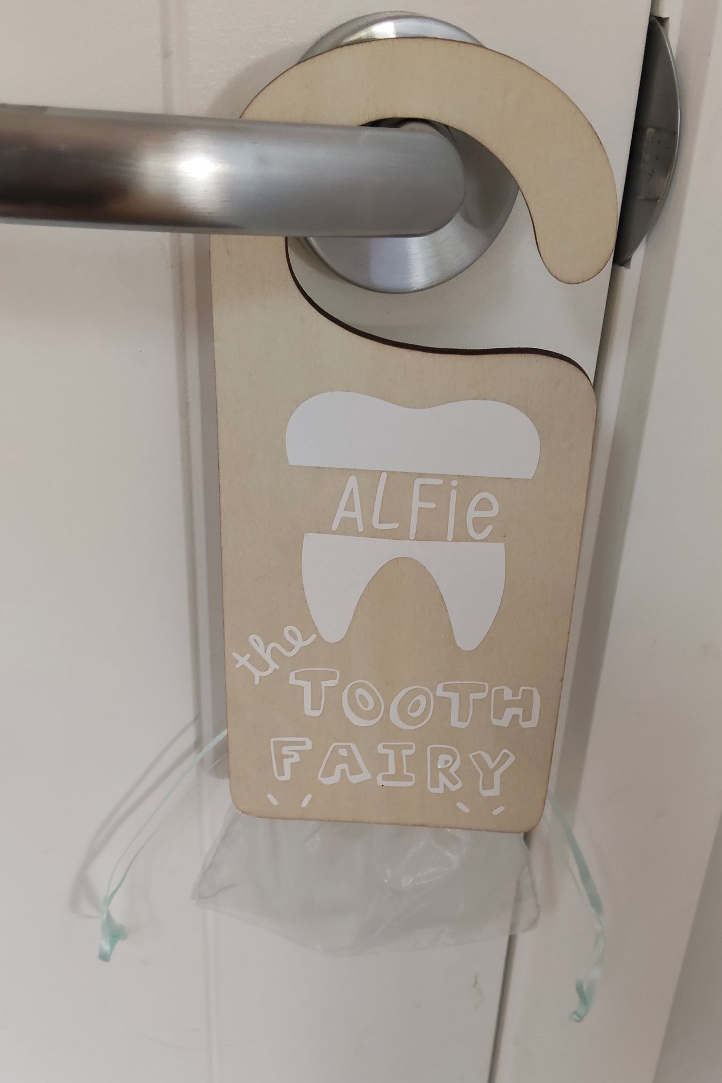 Door handle with a 'Tooth Fairy' holder personalised with name, lost tooth bag attached 