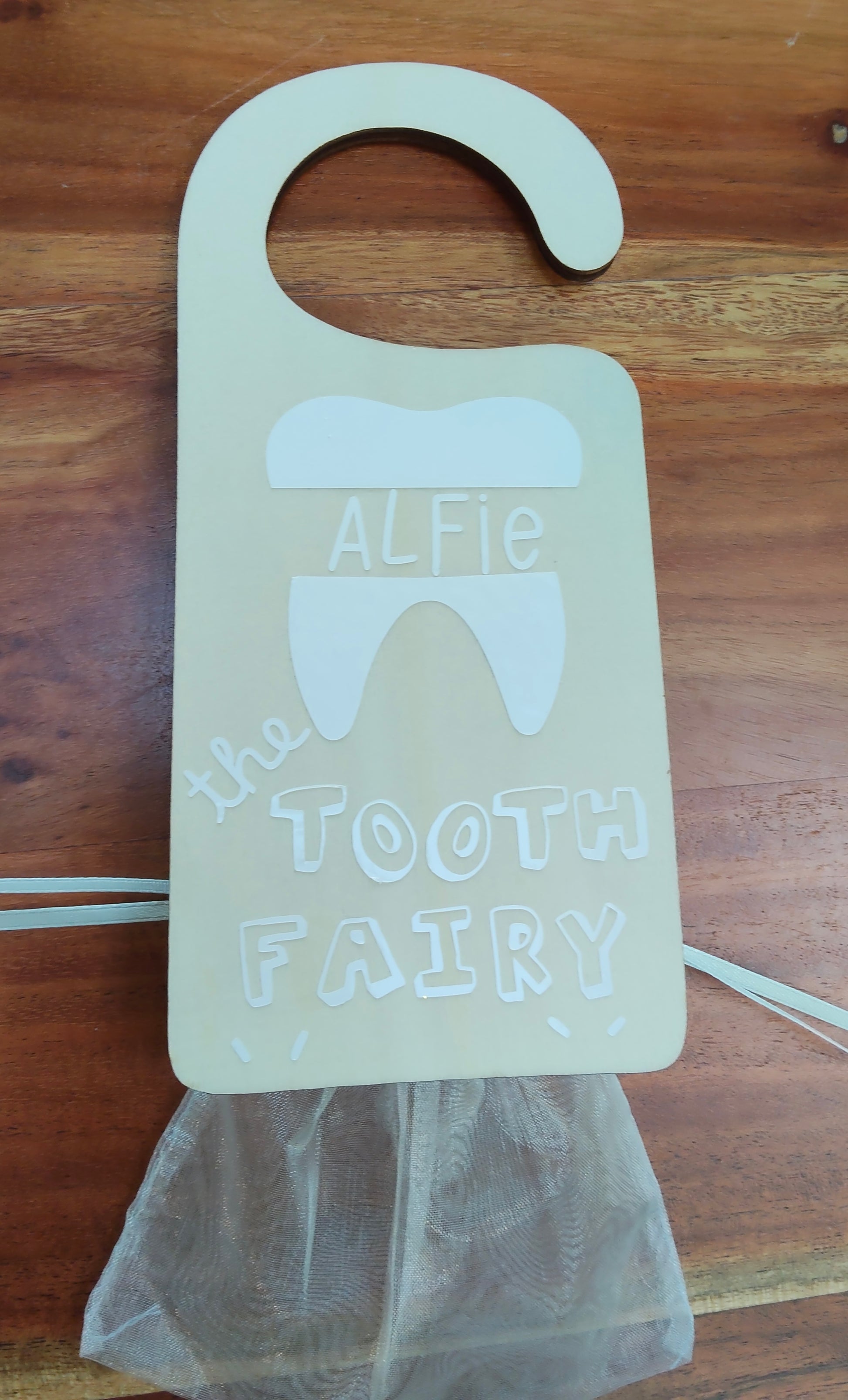 Door handle with a 'Tooth Fairy' holder personalised with name, 'lost tooth' bag attached. 