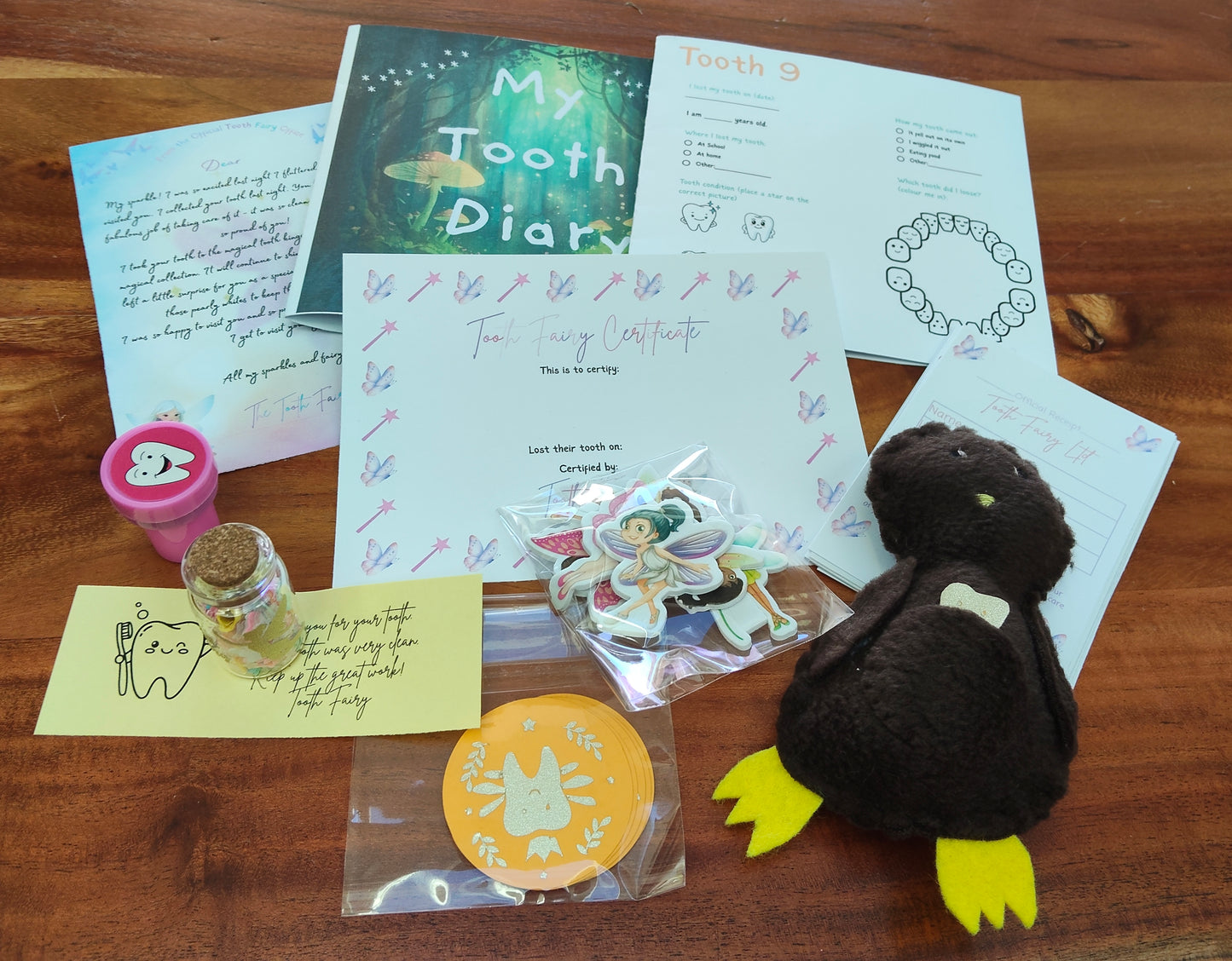 Collection of items including a tooth fairy letter, tooth fairy message in a bottle, tooth fairy receipts, letter from the tooth fairy, plush Kiwi Lost Tooth pouch. 