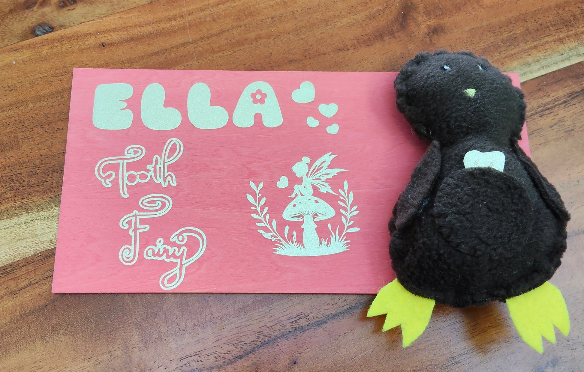 Brown plush Kiwi tooth pillow with yellow feet on a pink board featuring 'Personalised Tooth Fairy' design.