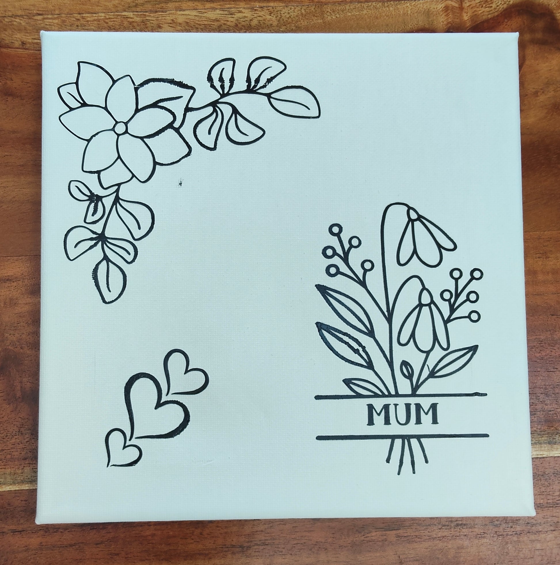 Set of floral and leaf designs on a white canvas with 'MUM' printed on it. 
