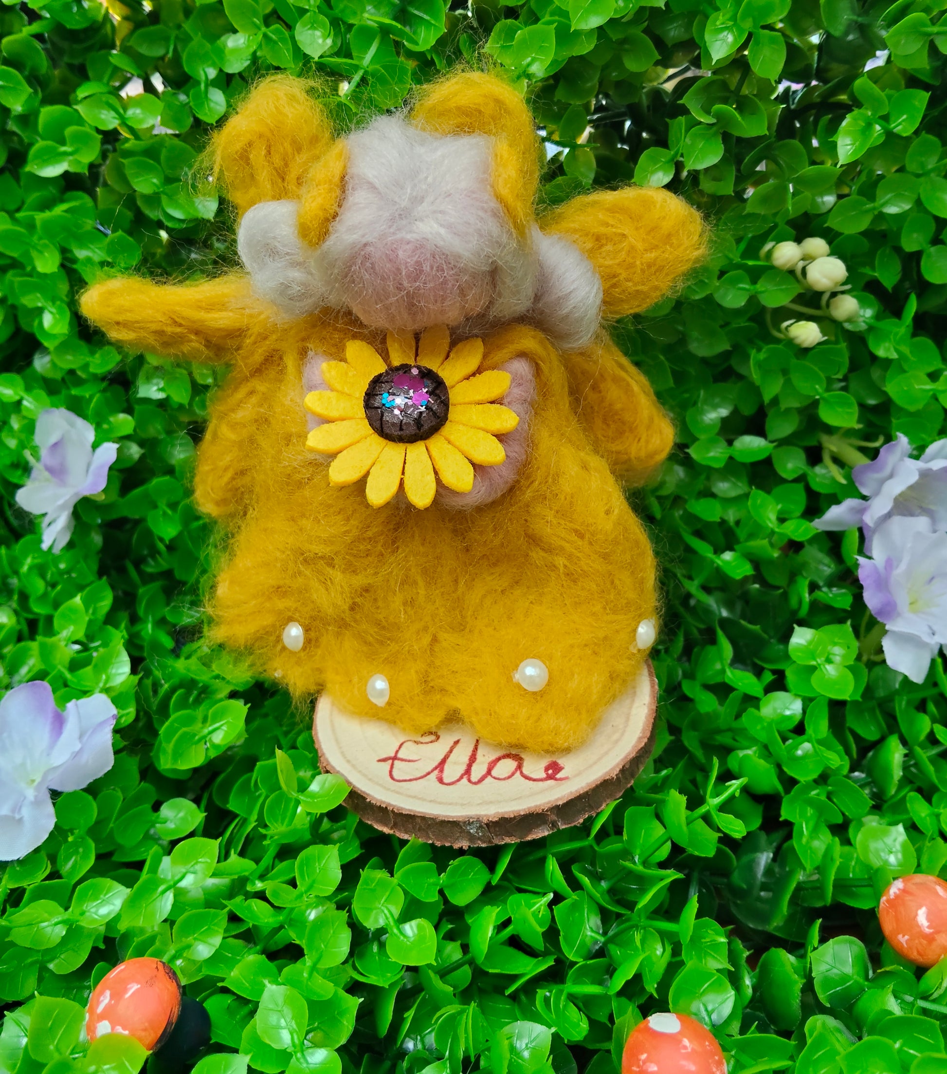 Yellow needle felted fairy with a sunflower design, complete with pearl decorations on a personalised name, wooden round stand. 
