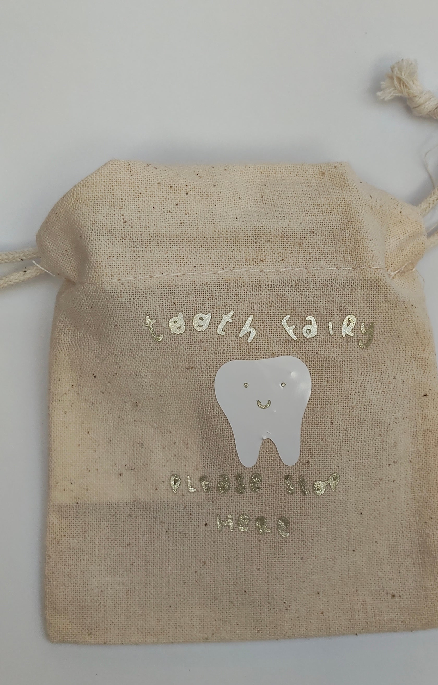 Burlap bag with a tooth design and text 'Tooth Fairy' Please Stop Here in gold glittery letters